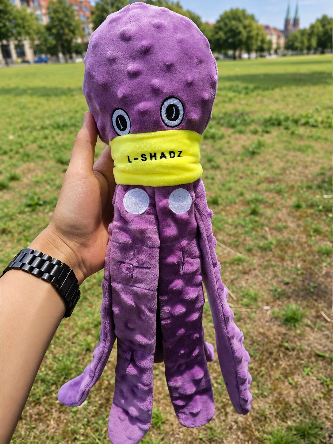 Lila Schnüffel-Oktopus für Hunde wird im Freien in einer Hand gehalten.